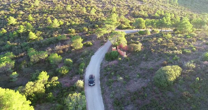 vehiculo 4x4 todoterreno conduciendo por carretera de monta&ntilde;a zona boscosa dron volando encima