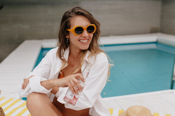 Stylish attractive caucasian woman with long wavy hair wearing white shirt smiling and looking away...