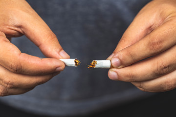 Stop smoking. Adult man breaking cigarette - Man Presenting Anti Tobacco Campaign Showing and Breaking a Cigarette in Hands