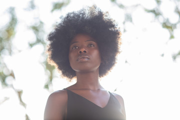 Young african american woman shot from below, confident look, determined