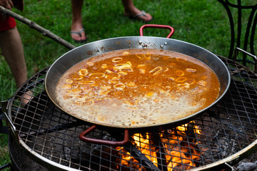 Preparando paella de marisco con fuego de leña