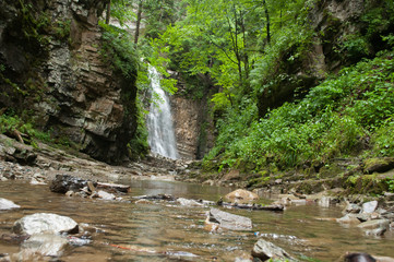 Waterfall in the mountains and green trees