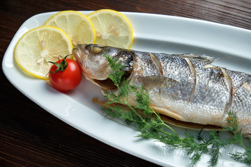 Grilled fish with a side dish and vegetables. restaurant menu
