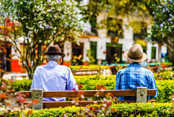 View on local men sitting on a bench in Jardin in Colombia