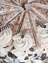 Tiramisu cake with paper dividers between portions and chocolate decorations
