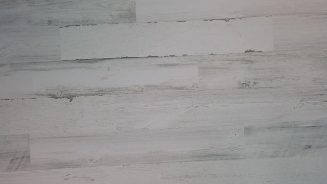 Hand picks up small uke off white wooden background, top down, 4k. Music concept