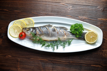 Grilled fish with a side dish and vegetables. restaurant menu