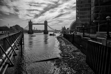 Classic monochrome silhouette view of Tower Bridge from the South Bank of the River Thames on a low tide morning in London, England, UK