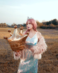 Elegant woman with crown holding balloon outdoors