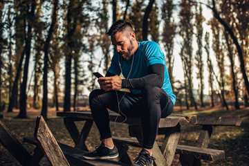 Fit man rest after jogging in the park.