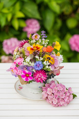 Colorful wild blossoms in a old coffee cup