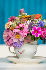 Colorful wild blossoms in a old coffee cup