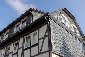 Architectural detail of typical half-timbered Vakwerk homes in the spa village of Grafschaft in the Sauerland region in Germany at sunset with clouds
