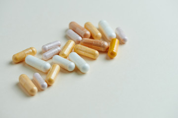 Vitamins on bright paper background. Concept for a healthy dietary supplementation. Close up. Copy space. 
