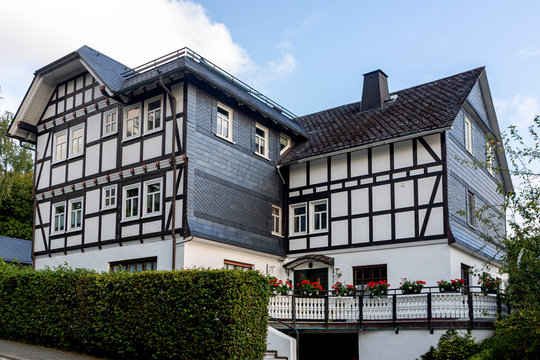Architectural detail of typical half-timbered Vakwerk homes in the spa village of Grafschaft in the Sauerland region in Germany at sunset with clouds