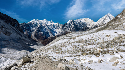 Snow covered mountain peaks in Himalayas,  Nepal during bright sunny day with blue sky.