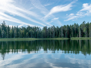 Fototapeta premium beautiful lake view, beautiful sky, Calm lake reflection against the blue sky with white clouds, Valdis lake, Turna, Latvia
