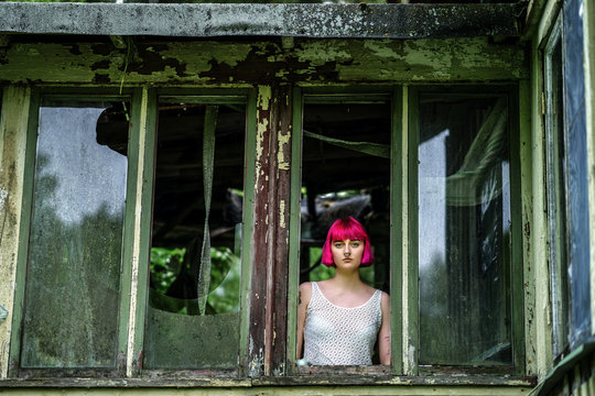 Pink Hair Swedish girl looking to out from old ruin house