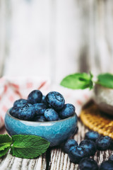 Myrtilles du jardin et menthe fraiche dans un pot en céramique bleu
