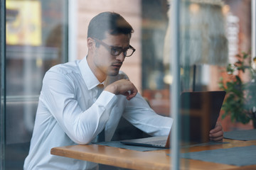 young man sitting on bench and talking on cell phone