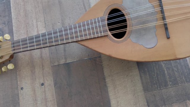 Slowly panning across a vintage ukulele on wood background, flat lay 4k.