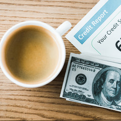 top view of cup with coffee near paper with credit report lettering on paper and money