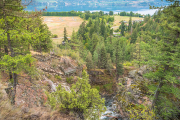 View from above of Shorts Creek Gorge and lower viewing platform above Fintry Falls with Okanagan Lake in distance