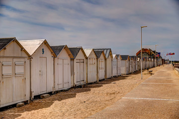 Beach huts along the boardwalk in Normandy France