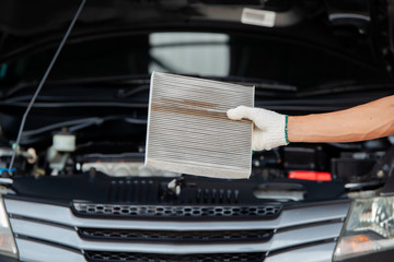 close up of Auto mechanic hands checking an air filter in garage.