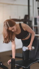 Fototapeta na wymiar Beautiful asian athletic woman lifting weights inside home gym