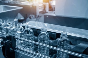 The PET bottles on the conveyor belt for filling process in the drinking water factory. The...