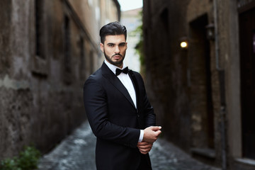 Businessman with james bond dress in little street in Rome - obrazy, fototapety, plakaty