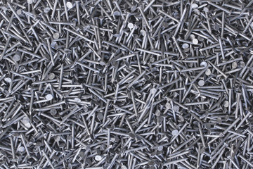 Background of metal nails top view close-up. Background from a variety of building steel sharp nails macro. A big pile of nails.