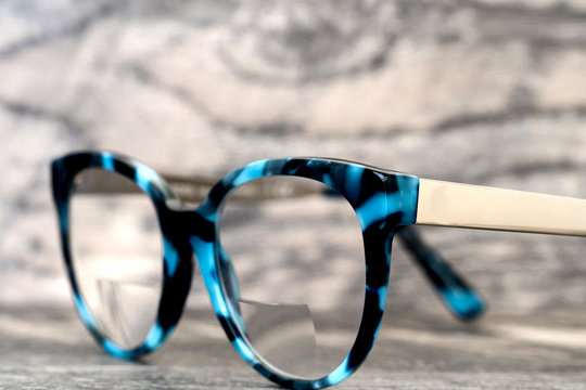 Eyeglasses Glasses with Bifocals and Black Blue Frame Fashion Vintage Style on Wood Desk Background, Rustic Still Life Style...