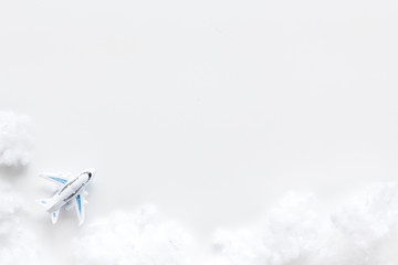 Fly by plane concept. Airplane model and clouds on white background top view frame space for text