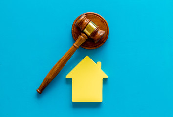 Inheritance of the house concept with figure and gavel on blue background top view