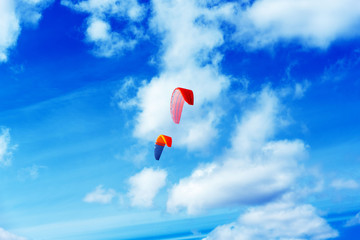 Colorful kites flying in a blue sky with air clouds.