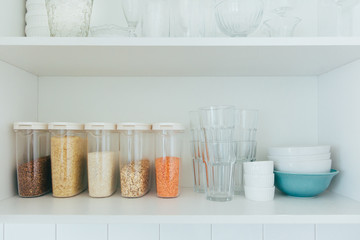 Various seeds in storage jars in pantry, white modern kitchen in background. Smart kitchen...