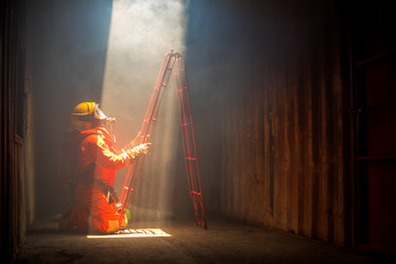 A Firefighter are preparing stairs to help people in the building, in the case of fire.
