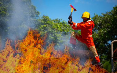 Firefighters use an ax to block the fire source from spreading to other locations.
