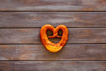 Octoberfest symbol. Fresh bavarian pretzels on dark wooden background top view copy space