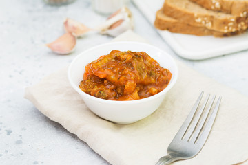 Bread with vegetable caviar on a white tray on a light gray background