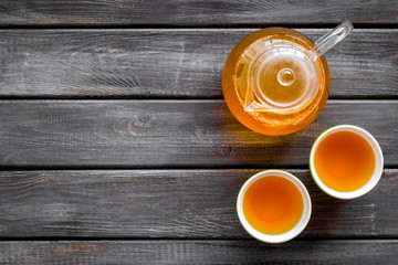Tea ceremony with brew in a pot and cups on wooden background top view copyspace