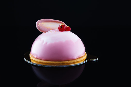 Mousse cake with strawberry puree, yourt cream and fresh fruits on black background