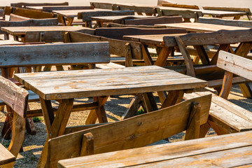 Many wooden tables and benches. The summer season is over. No visitors to the beer bar.