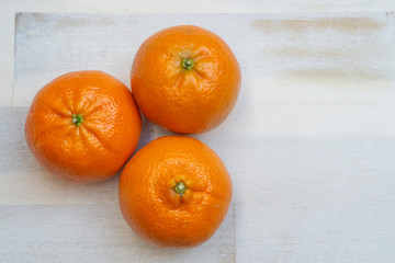 Group of three mandarines on wooden background