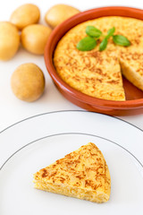 Piece of Omelet with eggs and potatoes isolated on white background. Homemade typical tortilla.