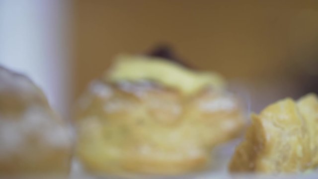 Macro backlit of man getting a delicious sweet cream pastry with fresh cream and a black cherry. Food concept. Italian zeppole di San Giuseppe.