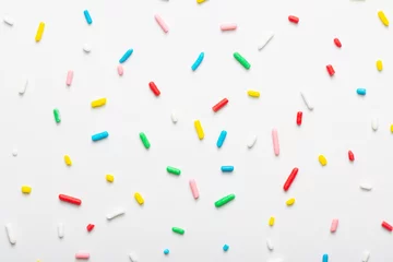 Foto op Plexiglas flat lay of colorful sprinkles over white background, festive decoration © Alisa