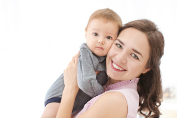 Loving mother with her baby on light background